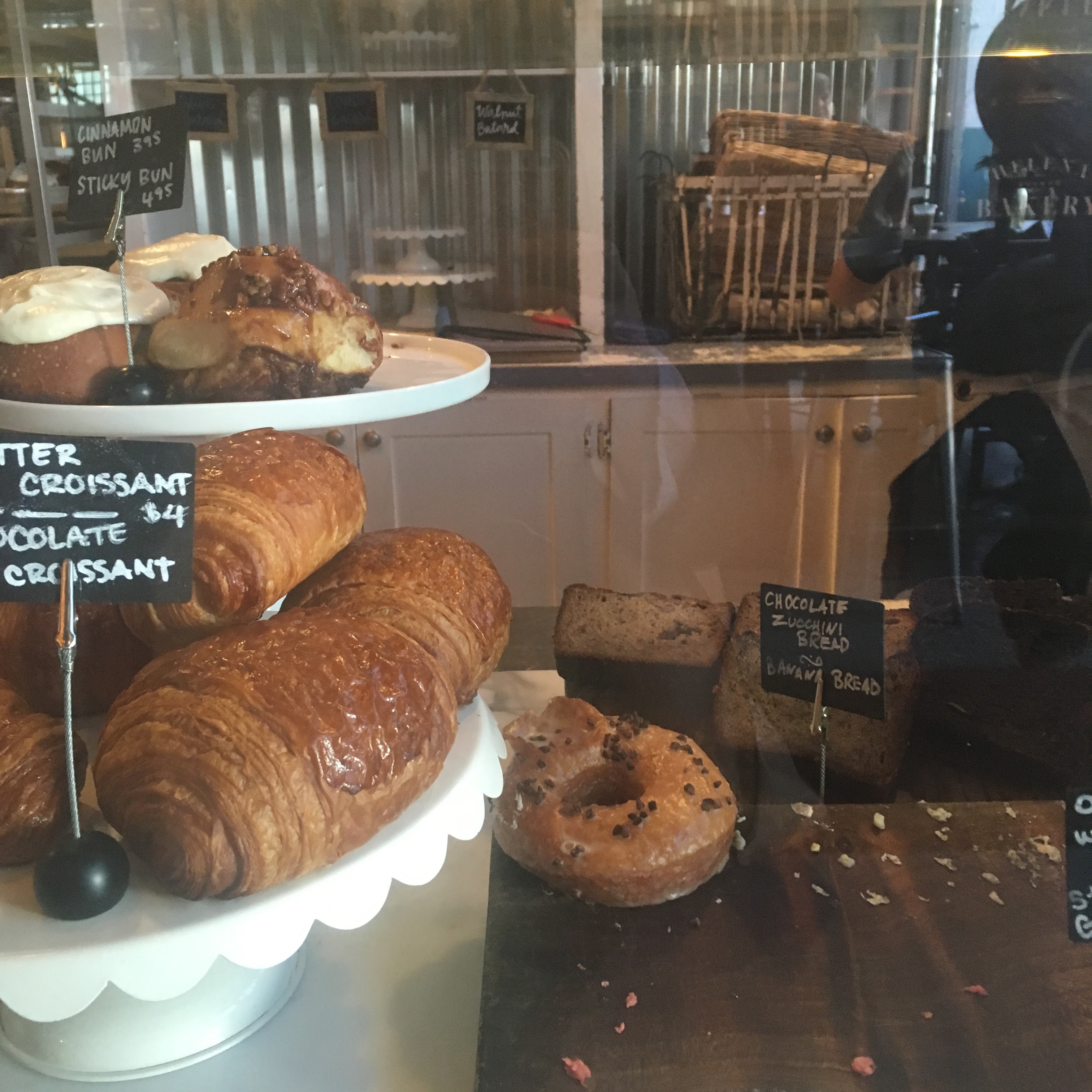 pastry case with croissants and sticky buns